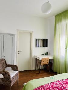 米兰Via Padova 165的一间卧室配有一张床、一张桌子和一把椅子