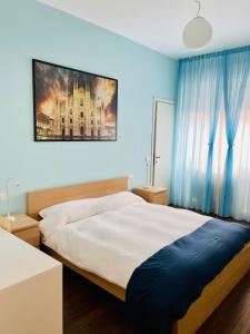 米兰Via Padova 165的一间卧室配有一张带蓝色墙壁的大床