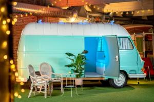 阿姆斯特丹Outside Inn的蓝白色的面包车,配有桌椅