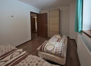迪马诺卡多林纳Apartmany Maliarik的铺有木地板的客房内的两张床