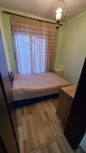 蒂瓦特Apartment SIDRO Tivat的一间卧室设有一张床和一个窗口