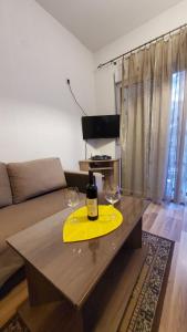 蒂瓦特Apartment SIDRO Tivat的客厅的桌子上放有一瓶葡萄酒和两杯酒