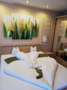 艾格扎洛克Kék Lagúna Wellness Apartmanok的卧室配有两张白色床,墙上挂有绘画作品