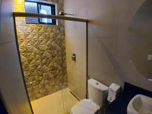贝洛奥里藏特Motel Caribe的带淋浴、卫生间和盥洗盆的浴室