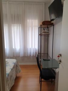 洛格罗尼奥Pensión Sotelo的一间卧室配有书桌、床和窗户。