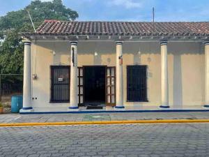 特拉科塔尔潘Hotel Casa Blanca by Rotamundos的街道上有柱子和门的建筑物