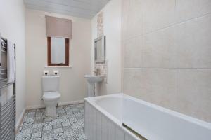 普雷斯蒂克Prestwick Central - Donnini Apartments的带浴缸、卫生间和盥洗盆的浴室