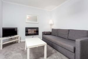 普雷斯蒂克Prestwick Central - Donnini Apartments的客厅配有灰色的沙发和电视