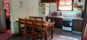 马德普拉塔Casa con piscina en Sierra de los Padres的厨房配有木桌和椅子