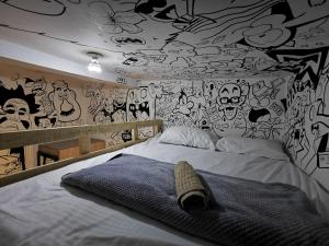 波帕扬Lienzo Hostel and Mural Art Museum的一间卧室配有一张涂有涂鸦墙的床