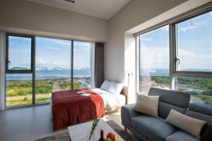 仁川市Blue Ocean Residence Hotel的一间卧室配有一张床、一张沙发和大窗户