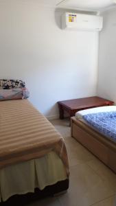 珀斯DIANELLA Budget Rooms Happy Place to Stay & House Share For Long Term Tenants的一间卧室配有两张床和一张桌子