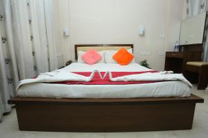 阿鲁法Hotel Innate Inn的床上配有橙色和粉红色的枕头