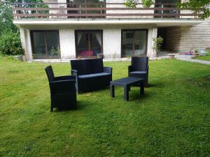 埃尔芒翁维尔Les Sabots du Parc的草上三把椅子和一张桌子