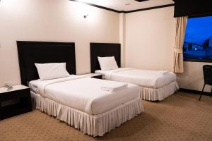 勿洞Betong Hello Hotel的酒店客房设有两张床和窗户。