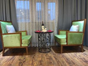 河内Hanoi Center Silk Hotel & Travel的一张桌子、一瓶葡萄酒和两把椅子