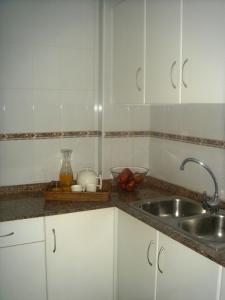 洛斯阿尔卡萨雷斯Apartamentos Margoysa I的厨房配有白色橱柜和水槽