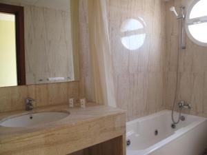 马尔格莱特德玛瑞玛酒店的一间带水槽、浴缸和镜子的浴室