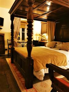 MallwydThe Firecat Country House Guesthouse的一间卧室配有一张带木制天篷的大床