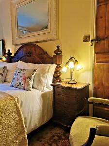 MallwydThe Firecat Country House Guesthouse的一间卧室配有一张床和一张带台灯的桌子