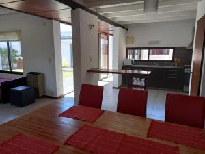 阿肖海Casa para 4 a 6 huespedes的厨房配有木桌和红色椅子