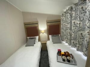 贝塞斯达C04 - Beechwood Lodge with Hot Tub的两张床铺,位于一间酒店客房内,配有一个化妆品托盘