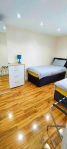 曼彻斯特133 A Park Road的一间卧室设有两张床,铺有木地板