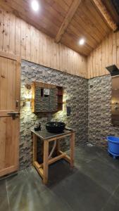 吉布LITTLE WOOD TREEHOUSE的一间带水槽和石墙的浴室