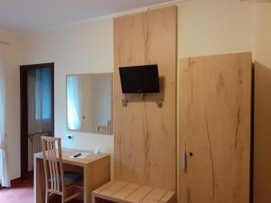 卡斯蒂奥内·德拉·佩雷索阿尔卑斯酒店的客房设有书桌和墙上的电视