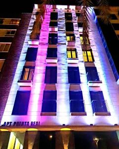 卡塔赫纳Apartamentos Turísticos Puerta Real的一座高大的建筑,晚上有灯