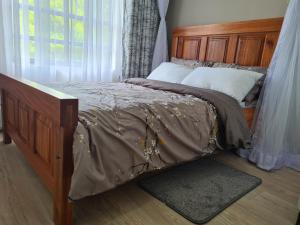 VipingoLovely 3-Bed Apt @Palm Ridge next to Vipingo Ridge的一间卧室配有一张带木制床头板的床和窗户。