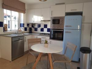 卡巴纳斯·德·塔维拉Penthouse Puro的厨房配有桌椅和冰箱。
