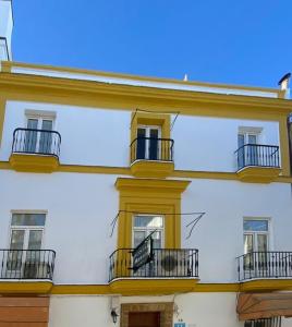 圣玛丽亚港Hostal Manolo的白色的建筑,设有窗户和阳台