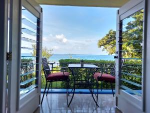 欧丘里欧Contemporary Ocean view 2bed Carib Ocho Rios Condo的一个带桌椅的海景阳台