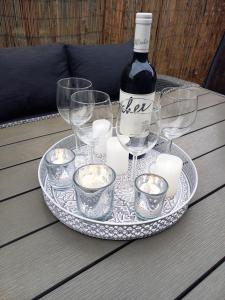 哈卡尼Gemini Vendégház的桌子上装有一瓶葡萄酒和眼镜的盘子