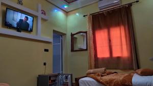 斯库拉Dar Calme Chez El Bouhali的一间卧室设有两张床,墙上配有电视。
