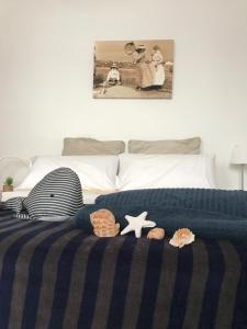 法马拉Lanzarote Famara Beach的一张带蓝色毯子的床和一些贝壳