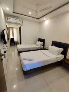 德瓦纳哈利-班加罗尔Airport Regency的酒店客房设有两张床和电视。