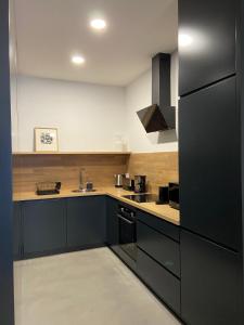 波尔图Mus Boavista的厨房配有黑色橱柜和黑色冰箱。