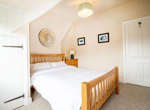 埃文河畔斯特拉特福Kerns Cottage Stratford-upon-Avon的一间卧室配有一张大床和镜子