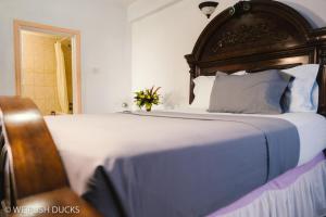 LaborieBelle View Apartment Villa- Lilac的卧室内的一张带木制床头板的大床
