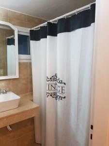 洛马斯-德萨莫拉PASAJE EN EL CENTRO DE LOMAS的浴室设有白色的淋浴帘和水槽