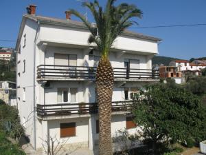 班约勒Apartment Miljenko- 150m from beach的白色建筑前的棕榈树