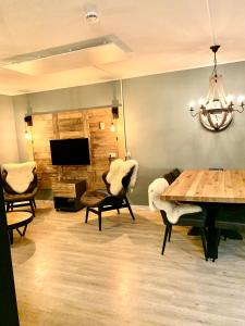 温特贝格Kappeberg Lodge的客厅配有桌椅和电视。