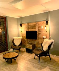 温特贝格Kappeberg Lodge的客厅配有2把椅子和平面电视