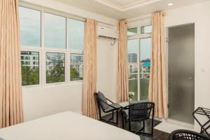 胡鲁马累Acacia Beach Hotel的客房设有窗户和桌椅。