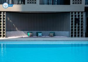 曼谷里诺酒店的游泳池畔的一张带枕头的床