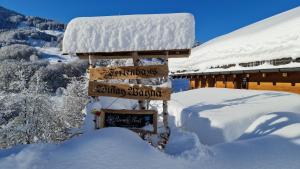 克洛斯特斯瑟纽斯Ferienhaus & Ferienwohnung Wiñay Wayna Gotschna Blick Klosters的小屋前雪上的标志