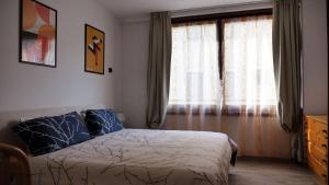 博尔米奥Al vecchio arcolaio的一间卧室配有床和带窗帘的窗户
