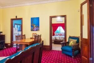 卡尔古利Allora House Kalgoorlie的一间带桌椅的用餐室和一间卧室